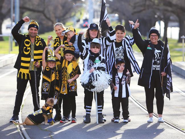 20/09/18 Richmond supporters (L-R) Jess and Anthony Aloi with their kids Arabella (7), Alfie (5) and Charlie (3) with Collingwood supporters (L-R) Ebony Smith (9), Kerri Watts, Damion Lumani (13), Mason Banting (3) and Lorraine Boateng on the corner of Hoddle Street and Victoria Parade in Melbourne where the two suburbs meet. Aaron Francis/The Australian