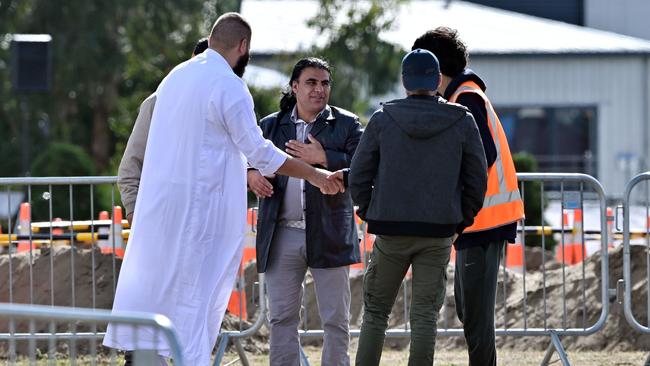 Abdul Aziz, centre, who tried to distract the attacker at one of the mosques, meets fellow community members prior to the funerals at the Memorial Park Cemetery. Picture: Anthony Wallace/AFP