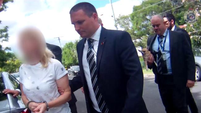 Detectives lead Maree Crabtree (faced blurred) away following her arrest in 2018.