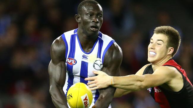 MELBOURNE, AUSTRALIA — MAY 14: Majak Daw of the Kangaroos is tackled by Zach Merrett of the Bombers during the round eight AFL match between the Essendon Bombers and the North Melbourne Kangaroos at Etihad Stadium on May 14, 2016 in Melbourne, Australia. (Photo by Scott Barbour/Getty Images)