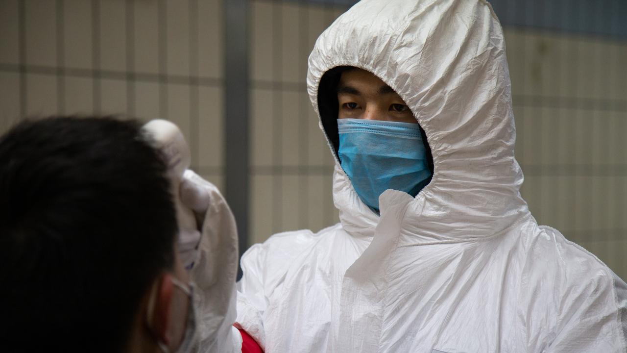 A health worker checks the temperature of a man entering the subway on January 26, 2020 in Beijing, China. Picture: Betsy Joles/Getty Images