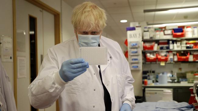 Boris Johnson looks at an immunological assay during a visit to the Jenner Institute in Oxford, England, who are leading the COVID-19 vaccine research. Picture: Getty