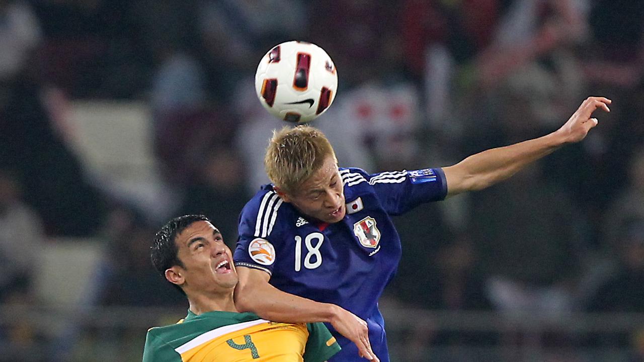 Japan's midfielder Keisuke Honda (R) jumps to head the ball as he vies with Australia's striker Tim Cahill