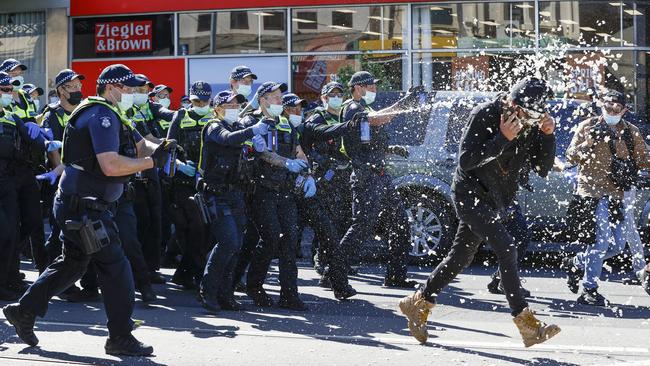 Police pepper spray a demonstrator. Picture: Alex Coppel