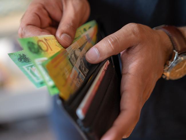 a male taking money out of a wallet, Australian cash generic spending