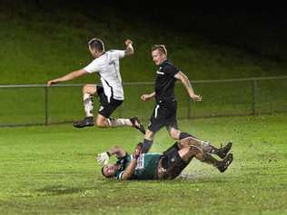 UNDER PRESSURE: Willowburn FC's Brodie Welch leaps over a sliding Alex Saunders (Willowburn White) during their Toowoomba Football League Premier Men's match at Commonwealth Oval on Saturday night. Picture: Kevin Farmer