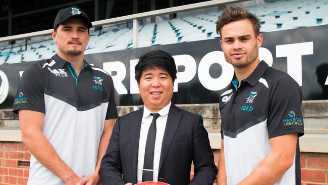 Nicho Teng (Greaton managing director) with Port players Sam Powell-Pepper and Karl Amon. Picture: supplied