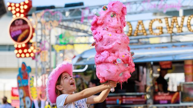 Celeste Patience, 9, with a giant fairy floss, in strawberry, bubblegum and unicorn flavours, at the Sydney Royal Easter Show on Sunday. Picture: Justin Lloyd