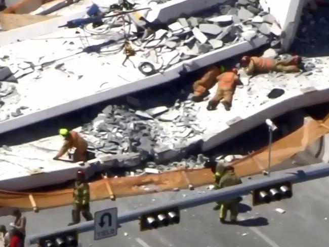 Rescuers crawled under the rubble in an effort to save people crushed after the bridge flattened cars on the highway at Florida International University. Picture: Twitter @NBCNews