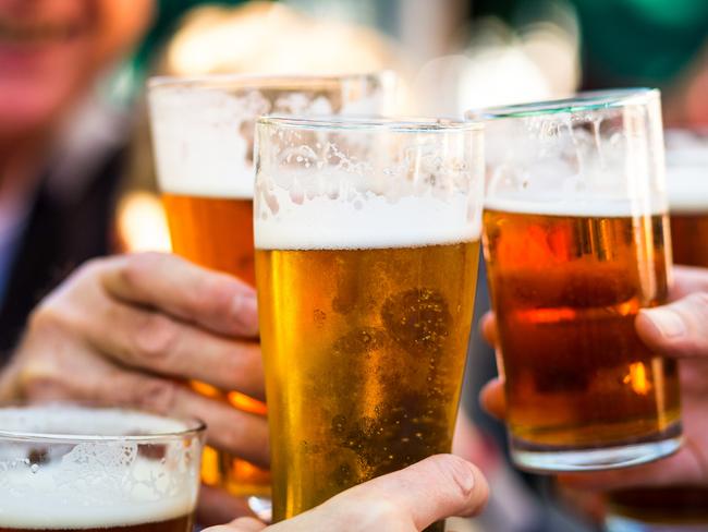 Close up color image depicting a group of people celebrating with a toast. The people cheers their glasses of beer (pints of beer) together in a gesture of celebration, togetherness and happiness. The people are defocused in the background, while focus is on the glasses of beer in the foreground.photo istockescape 3 april 2022savvy