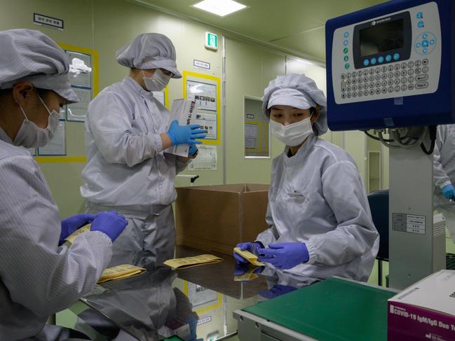 COVID-19 novel coronavirus testing kits are packaged on a production line at the SD Biosensor bio-diagnostic company near Cheongju, south of Seoul on March 27, 2020. - SD Biosensor is one of five companies in South Korea -- which appears to have brought its epidemic under control with a huge "trace, test and treat" effort -- making diagnostic tests for the COVID-19 virus. (Photo by Ed JONES / AFP)