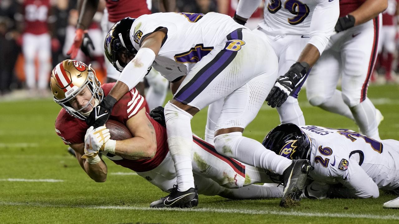 SANTA CLARA, CALIFORNIA - DECEMBER 25: Christian McCaffrey #23 of the San Francisco 49ers dives past Marlon Humphrey #44 of the Baltimore Ravens while scoring a rushing touchdown during the second quarter at Levi's Stadium on December 25, 2023 in Santa Clara, California. (Photo by Thearon W. Henderson/Getty Images)