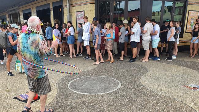 A busker provides entertainment for those waiting in the long queue for Splendour in the Grass locals' tickets at the Great Northern Hotel earlier this year, before COVID-19 restrictions saw busking temporarily banned in the shire.