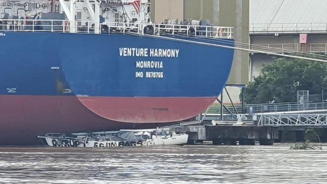 A smaller boat that became lodged underneath a large ship on the Brisbane river on Monday. Picture: Picture: VMR 447 – Redland Bay/Facebook