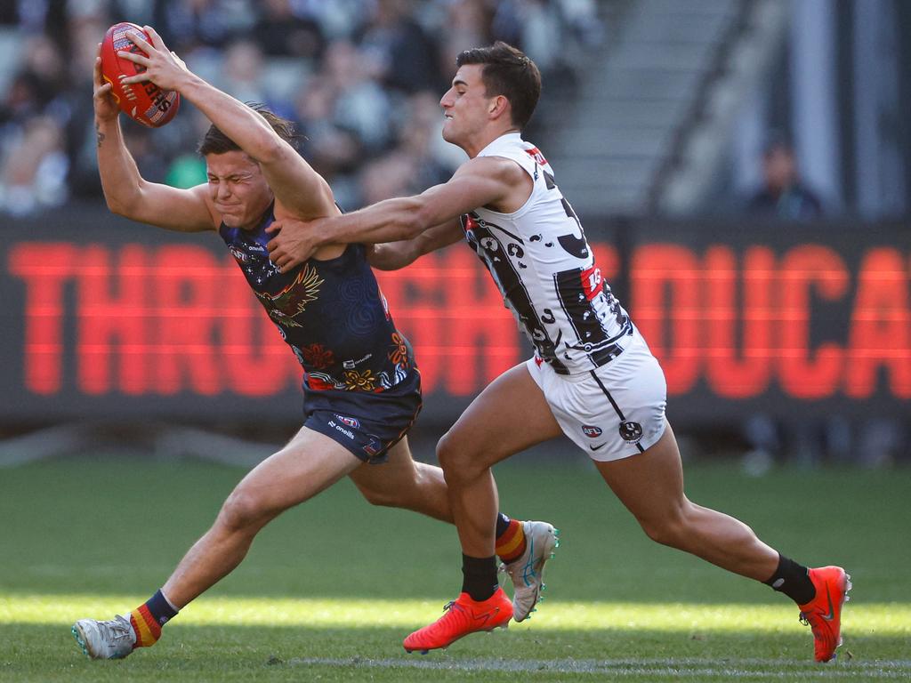 Jake Soligo is tackled by Nick Daicos. Picture: Dylan Burns/AFL Photos