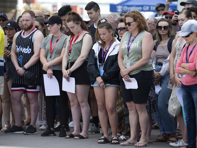 People bow their heads in silence, remembering those affected and killed by White Island’s volcano eruption. Picture: Brett Phibbs