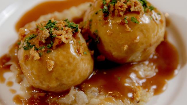 Potato dumplings filled with marinated pork crackling served on sauerkraut. Photo: Adam Ward