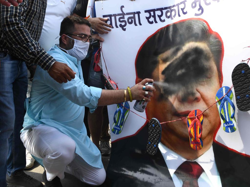 Bharatiya Janata Party activists spray black paint on a poster depicting Chinese President Xi Jinping during an anti-China protest in Amritsar in June. Picture: Narinder Nanu / AFP