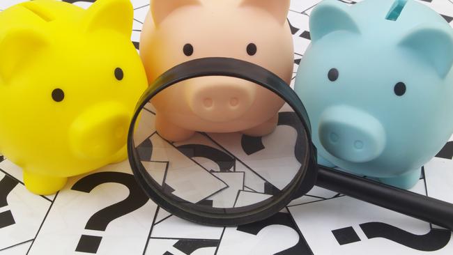 Three piggy banks under magnifying glass on question marks background. Saving money concept; superannuation saving generic