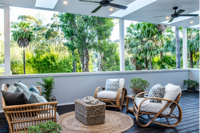 Plenty of palm trees can be seen by looking out into the backyard from the balcony.