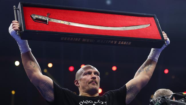 Oleksandr Usyk holds up a 'Ukraine Wow: Mazepa's Saber' following the victory. (Photo by Richard Pelham/Getty Images)