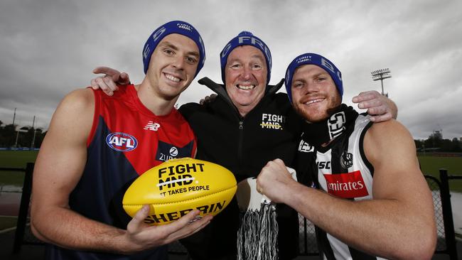 Neale Daniher warms up for the battle ahead with AFL stars Jake Lever and Taylor Adams. Picture: David Caird