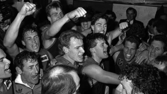 We did it! Dees (from left) Stephen Newport, Todd Viney, Steven Stretch, Jim Stynes, John Northey (back of head) Graeme Yeats, Steve Turner, Greg Healy, Brian Wilson and Brett Lovett live it up in the visitors' rooms at the Western Oval after learning of Hawthorn's win at Kardinia Park.