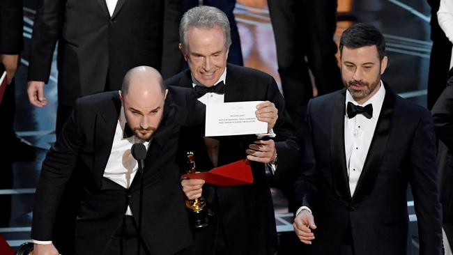 La La Land producer Jordan Horowitz holds up the winner card reading actual Best Picture winner 'Moonlight' with actor Warren Beatty and host Jimmy Kimmel. Picture: Getty