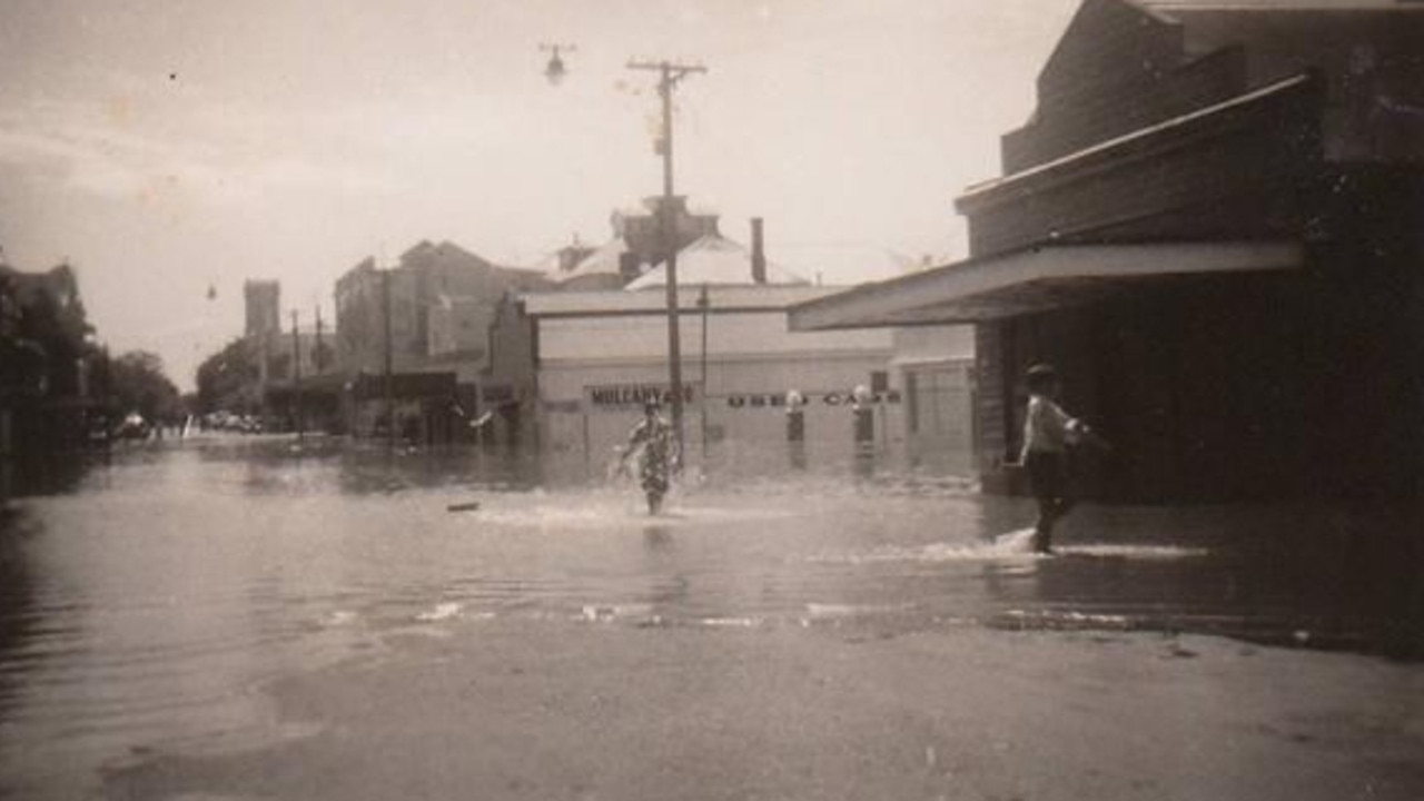 Row of shops submerged in the 1955 flood, Maryborough. A line of businesses standing resilient in the face of severe flooding. Source: Unknown