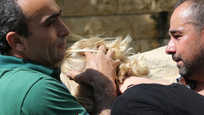 A Lebanese plainclothes policeman prevents Australian TV presenter Tara Brown from looking towards journalist. Picture: AP