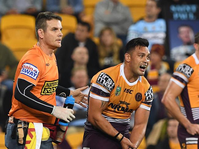 Alex Glenn of the Broncos holds his wrist as he is attended to by medical staff during the Round 20 NRL match between the Brisbane Broncos and the Cronulla-Sutherland Sharks at Suncorp Stadium in Brisbane, Thursday, July 26, 2018. (AAP Image/Dave Hunt) NO ARCHIVING, EDITORIAL USE ONLY