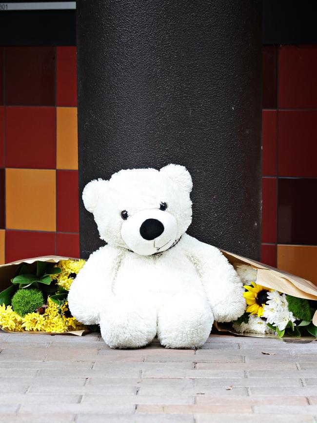 Flowers and a teddy left out the apartment block. Picture: Adam Yip