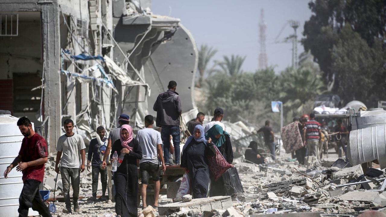 Palestinians who retuned briefly to eastern Deir al-Balah in the central Gaza Strip to check on property, carry away some items they were able to salvage amid the devastation, after Israeli troops pulled out from some blocks in the area. (Photo by Eyad BABA / AFP)