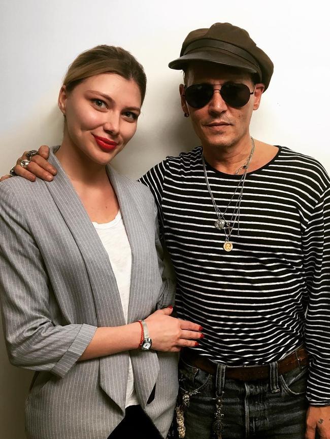 A skinny Depp poses with a fan.