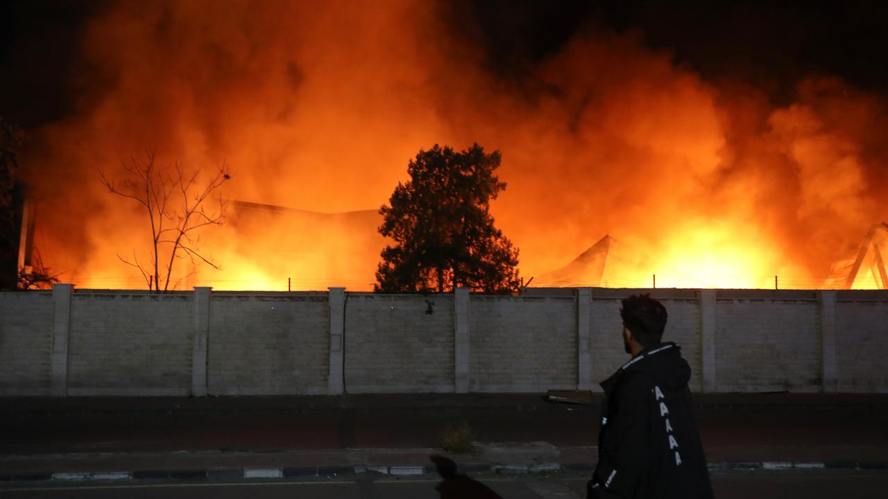 A person watches as a fire burns following explosions at a security compound that houses the Syrian Military Intelligence Interrogation Division. Picture: Getty