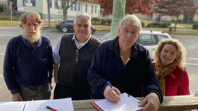 Peter Rubenach, Federal MP for Lyons Brian Mitchell, Break O'Day Council deputy mayor Jon McGiveron and former Labor state candidate for Lyons Janet Lambert signing a petition to keep the St Marys Commonwealth Bank branch open. Source: SUPPLIED.