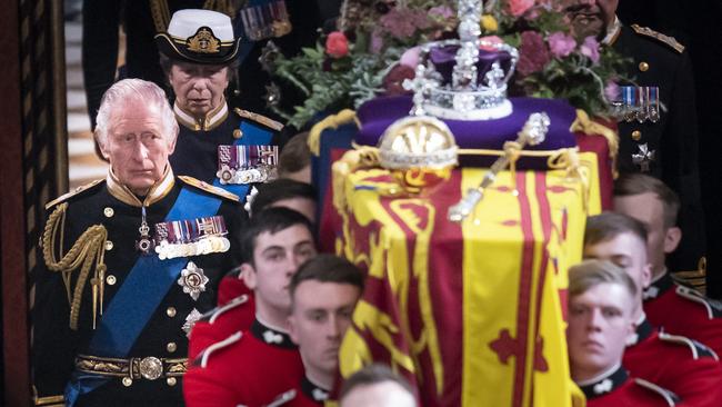 King Charles III follows behind the coffin of Queen Elizabeth II, draped in the Royal Standard with the Imperial State Crown and the Sovereign's orb and sceptre, as it is carried out of Westminster Abbey following the Queen’s funeral service. Photo by Danny Lawson - WPA Pool/Getty Images.