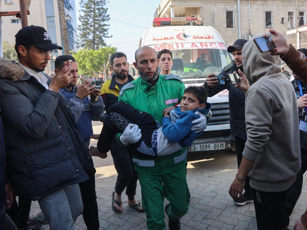 Palestinians transport casualties of Israeli strikes into at Al-Ahli Arab hospital, also known as the Baptist hospital, in Gaza City on January 13, 2025. (Photo by Omar AL-QATTAA / AFP)