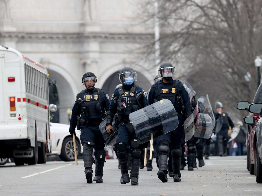 Police officers in riot gear walks towards the U.S. Picture: AFP