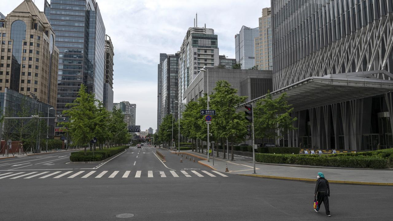 A woman crosses a nearly empty road in Beijing’s CBD days after the local government issued a work from home directive in an effort to contain a Covid outbreak. Picture: Kevin Frayer/Getty Images