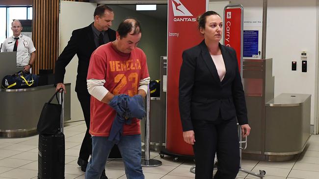 Detectives escort Paul Anthony Bennett through Darwin Airport. Picture: Katrina Bridgeford