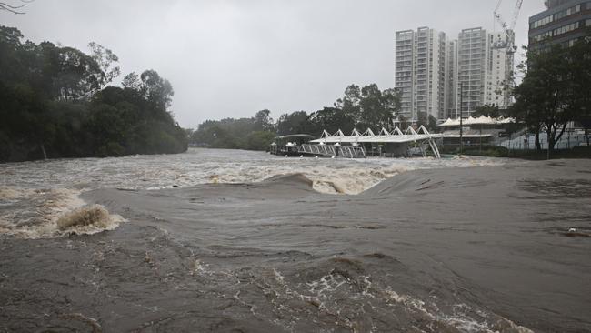 A torrent of rain floods the Parramatta River near the wharf. Picture: Adam Yip