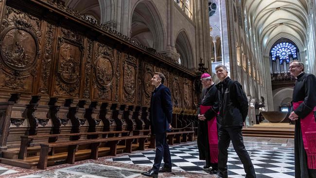 French President Emmanuel Macron (L) inspects immaculately restored woodwork inside the Notre Dame before it reopens on December 7. Picture: AFP