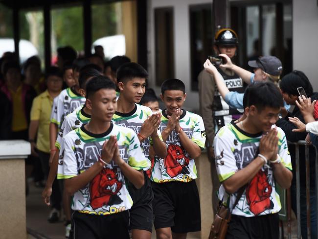 Some of the 12 Thai boys, rescued from a flooded cave after being trapped for more than two weeks, arrive to attend a press conference in Chiang Rai.