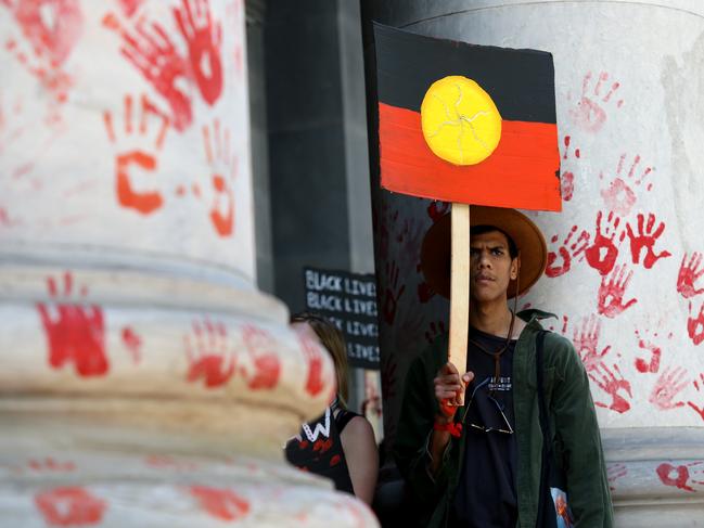 Protesters leave red paint hand prints on pillars during the protest outside the South Australian Parliament at Adelaide on Wednesday. Picture: Kelly Barnes