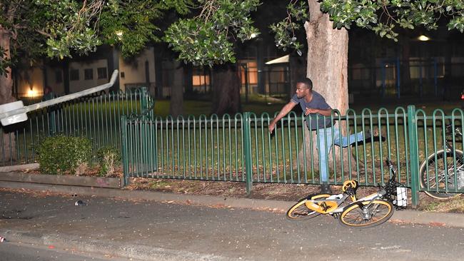 A man throws a street sign at police during riots outside Milo Yiannopoulos’ venue. Picture: Jake Nowakowski