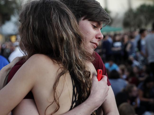 Julia Suconic, 15, hugs her friend Nathan Schoedl, 16, both students at Marjory Stoneman Douglas High School, before the start of a candlelight vigil for the victims of the Wednesday shooting at the school, in Parkland, Fla., Thursday, Feb. 15, 2018. Nikolas Cruz, a former student, was charged with 17 counts of premeditated murder on Thursday. (AP Photo/Gerald Herbert)