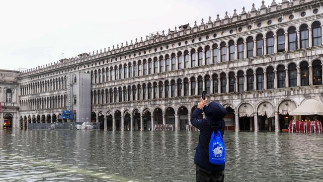 A visitor to the flooded St Mark's Square on November 24 2019. Photo by Miguel Medina/ AFP)