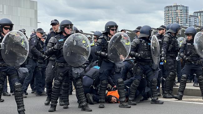 A protester is detained by police near the Melbourne Convention centre on Wednesday. Picture: Mohammad Alfares