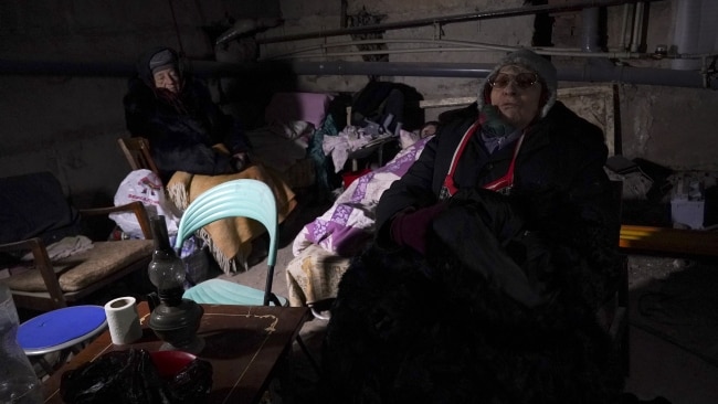 Two elderly civilians sheltering inside a bomb shelter underground as shelling and bombs drop from the sky. Picture: Getty Images